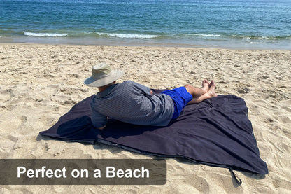 Man relaxing on the Ultimate Sportwrap using it as a beach blanket