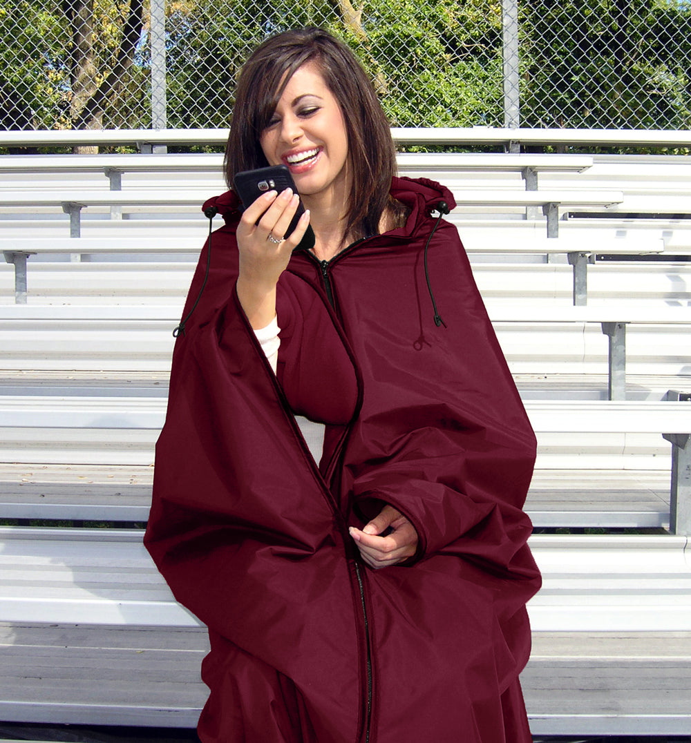 Woman Wearing a maroon Ultimate SportsWrap sitting on stadium bleachers hands free holding a mobile phone.